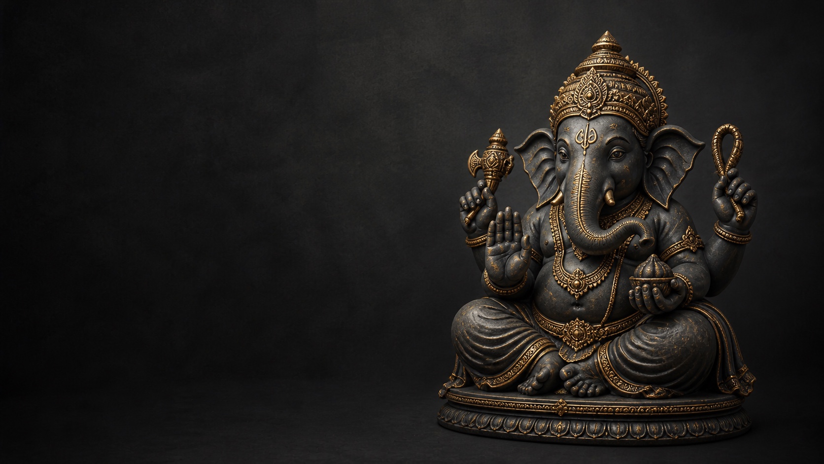 A graphite-gray Vinayaka idol with restrained antique-gold detailing